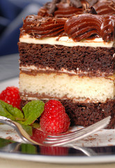 A piece of chocolate layer cake with raspberries