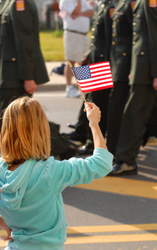 A girl waving an American flag during a parade
