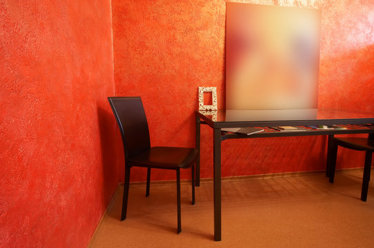 Chair and table on a background of a red wall