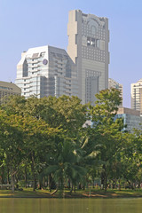 Obraz premium Modern office blocks with a lush tropical park in the foreground
