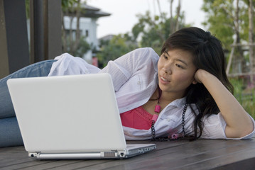 Naklejka premium Asian female outdoors with her laptop computer