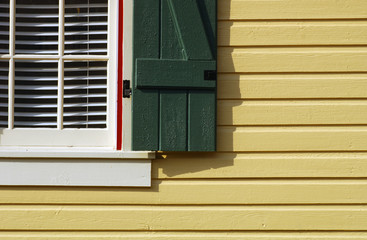 Image of a pretty gold house with a green shutter