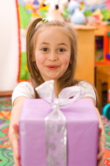 Fototapeta na wymiar Happy surpised girl showing the birthday present