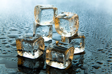 Melting ice cubes on reflective background