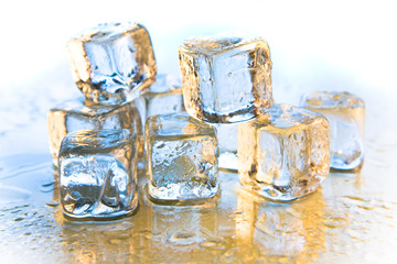 Melting ice cubes on reflective background