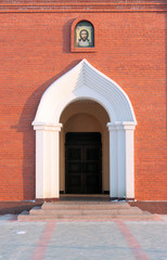 church entrance, arc in red brick wall