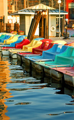 Row of bright paddle boats on the water