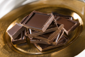 chocolate blocks on golden plate close up shoot