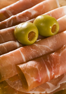 fresh prosciutto with olive fruits close up shoot