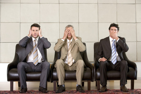 Three businessmen showing "hear, see, speak no evil"