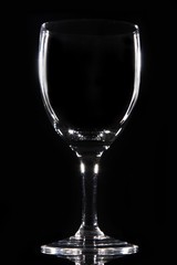 A single winegalss in black bacground with edge lights.
