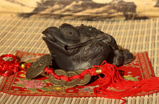 Three paws clay toad with a sheaf of "happy" Chinese coins