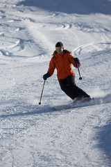 female skier on skiing track with powder in the background