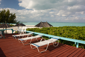 sun beds on wooden deck overlooking beach