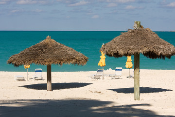 sun loungers under umbrellas on tropical beach