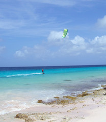 wind surfer glides along the ocean reef