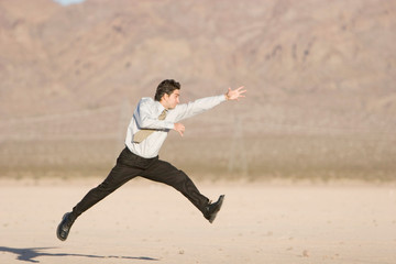 Happy businessman jumping in air