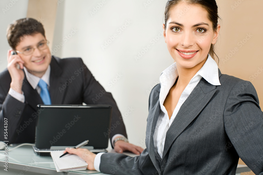 Poster Portrait of young business woman looking at camera in a office