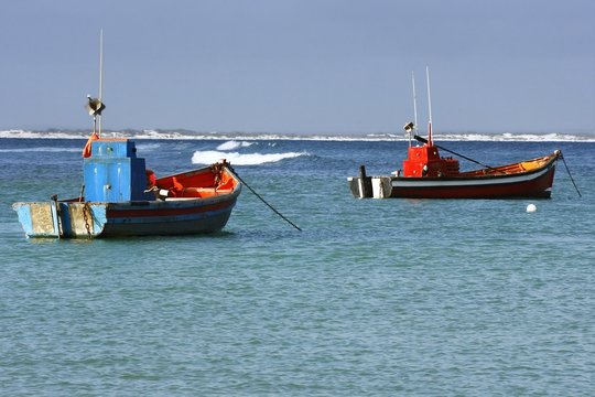 two colourful fishing boats moared in a small harbour