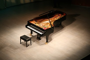 piano with  bouquet of flowers on scene in  concert hall