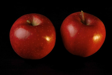 two red apples on black