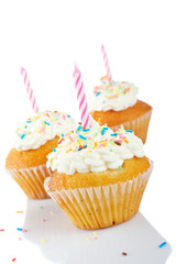 Muffins with candles isolated on white background. Shallow DOF