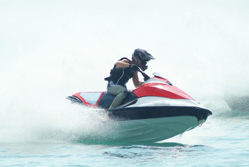 Man riding a powercraft through the sea spray