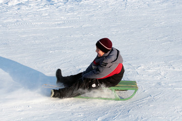 happy boy on sledge in bright winter day