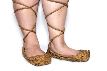 peasant woman legs in russian bast shoes on white background