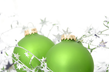 two green ornaments with silver stars 