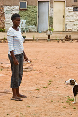 African woman with a puppy, rural area near Kalahari desert