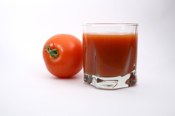 Glass of tomato juice and tomato on white backgrounf