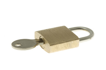 Closed brass padlock with key inside. Isolated