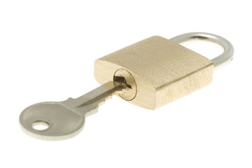 Closed brass padlock with key about to open it. Isolated