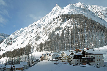 little village in winter on the bottom of mountain