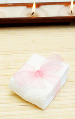 Relaxing spa scene with small white towel with pink organza