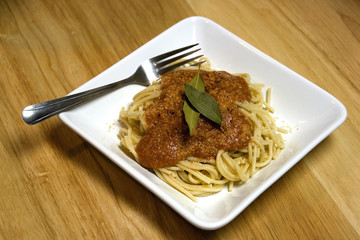 Plate of pasta and sauce on white plate.