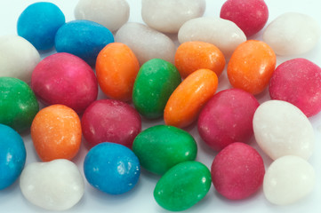 scatter multicolored icing glaze sweeties on white