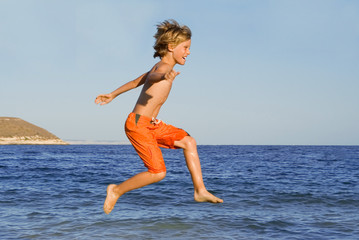happy child jumping on summer vacation - 5587910
