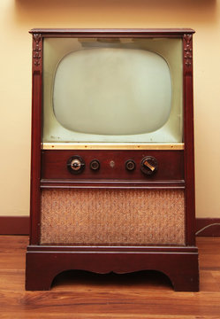 An old retro television with a small screen and a big speaker.