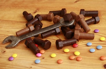 Chocolate screws and old metal spanner on the table