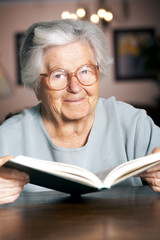 Elderly woman reading a book, portrait
