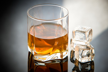 Whiskey in glass with ice cubes