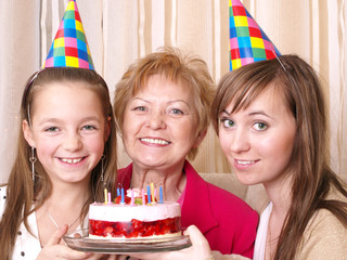 Daughter, mother and grandmother with birthday cake