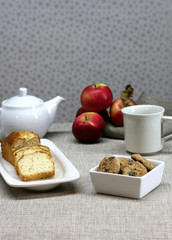 A table set for dessert with cookies, cake and tea