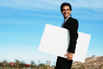 confident and successful businessman is holding a blank board