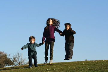 groupe d'enfants entrain de sauter sur l'herbe