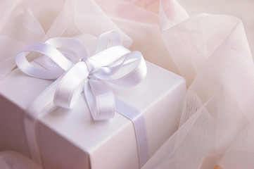 Present white box with silky ribbon in laces