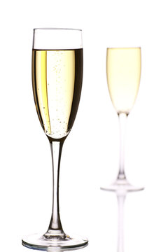 two champagne flutes, one  behind the other.