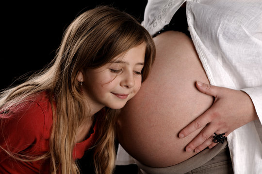 Enfant touche le ventre de sa m&egrave;re enceinte